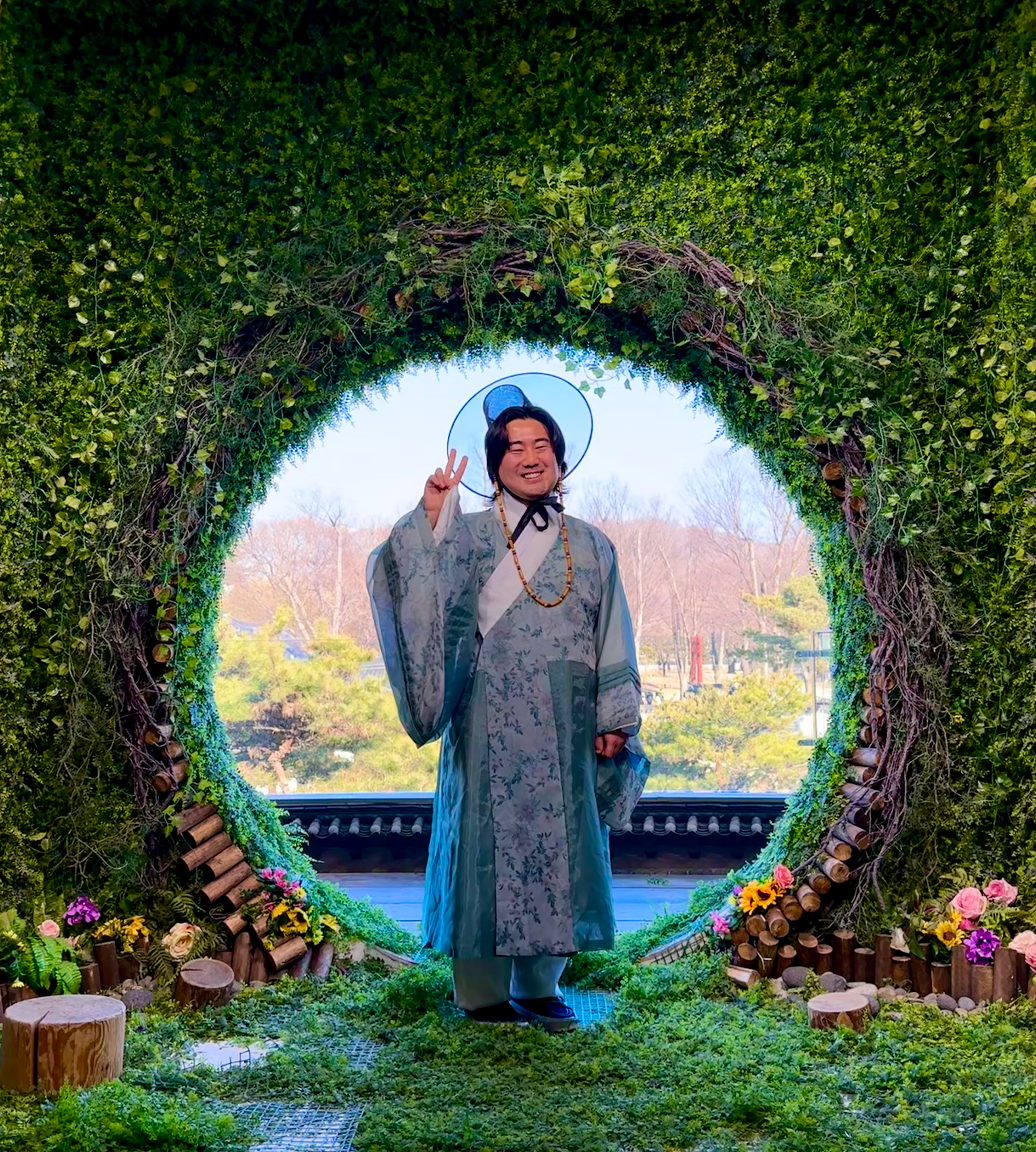 A student studying abroad at Yonsei National University posing in front of a green and floral backdrop